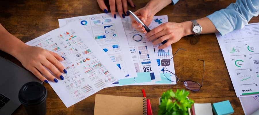 Équipe d’agence digitale travaillant ensemble sur des écrans avec graphiques et données marketing.